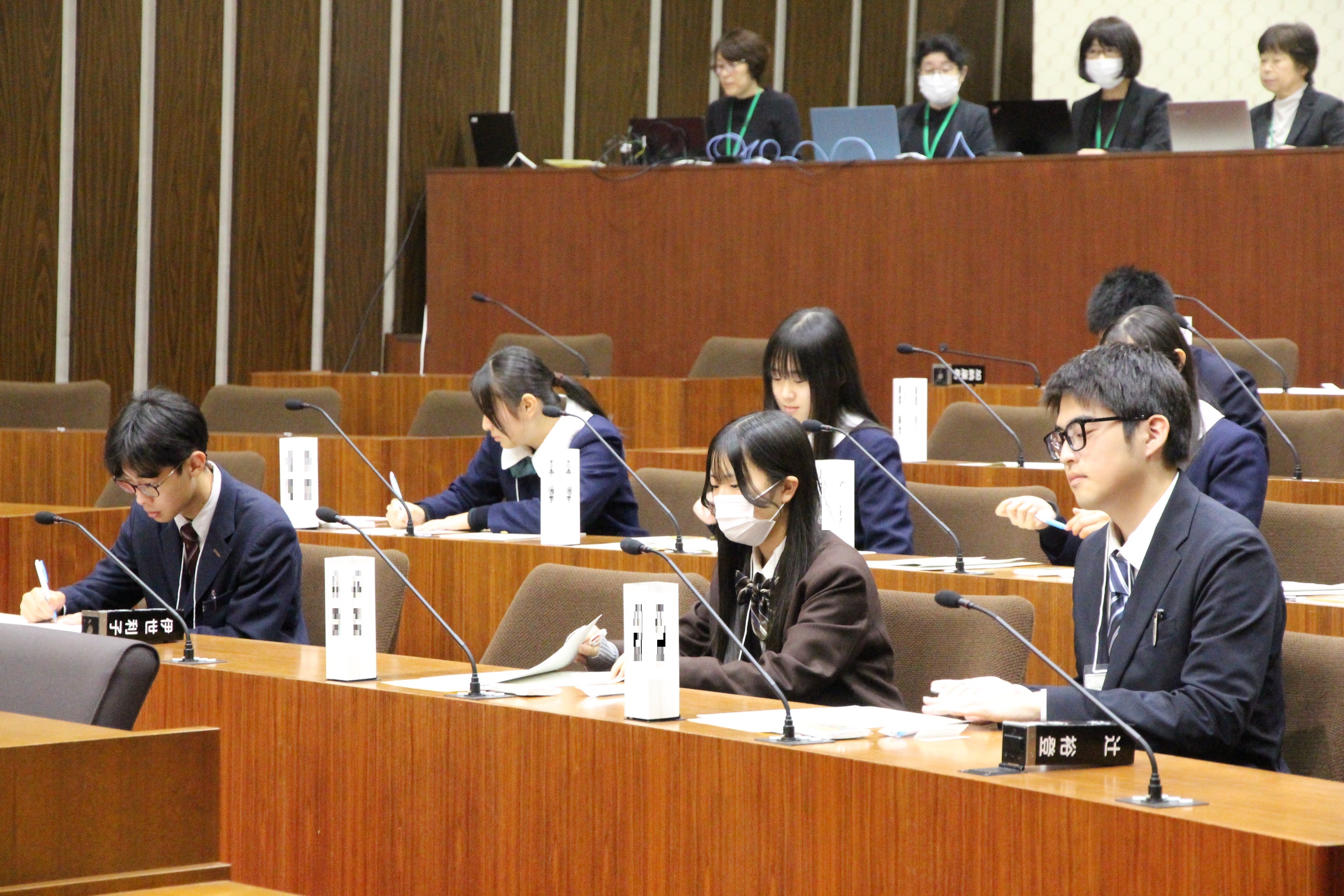 議長選出のために投票用紙に記入する高校生議員