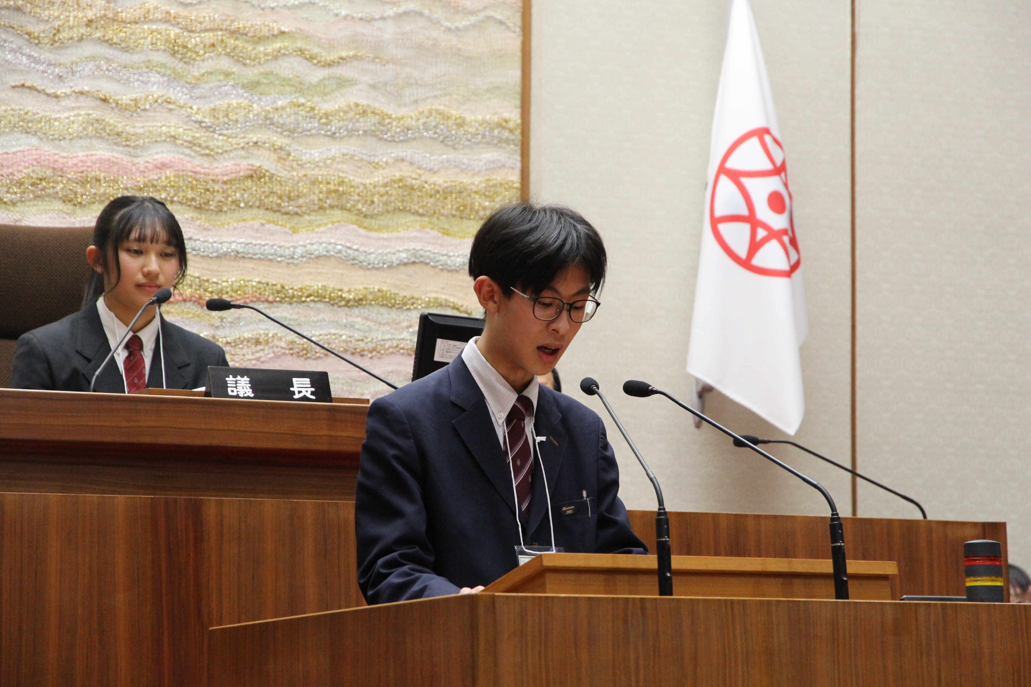 演台に立ちBグループの報告をする高校生議員